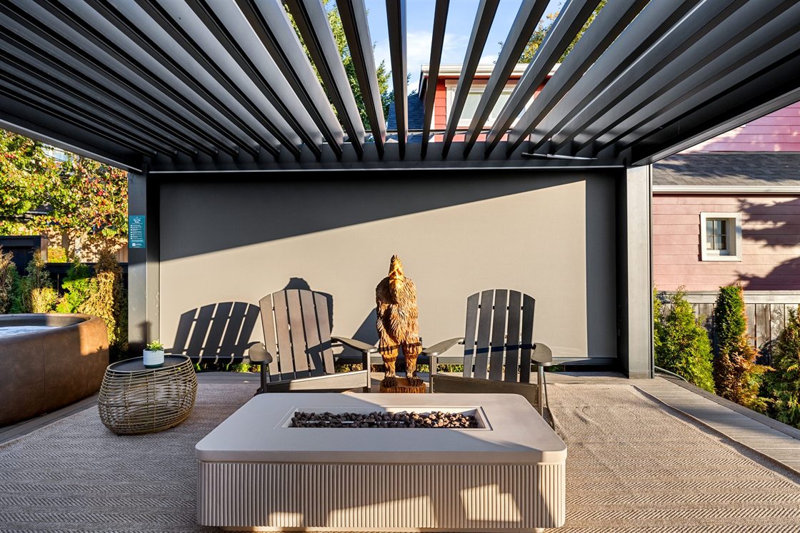 Fire table, Adirondack chairs and the Softub under the pergola of The Junction Retreat, a West Seattle Airbnb, photographed by Pacific Haus Media